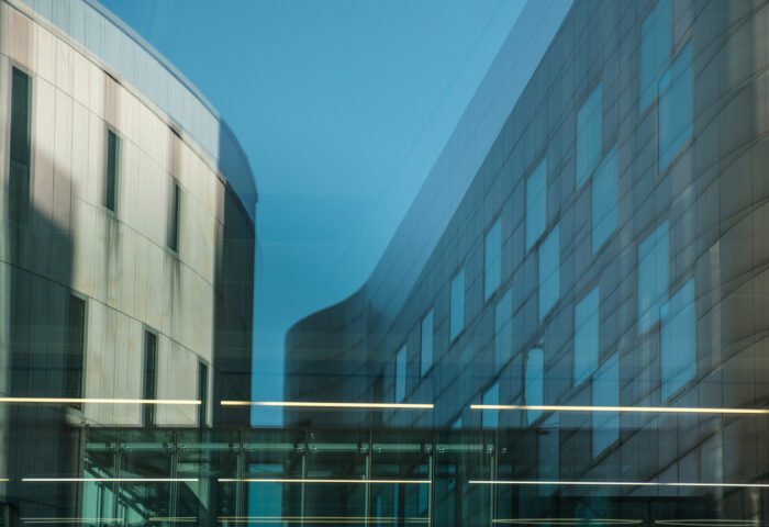 Błękitne zdjęcie przedstawia odbiy w obiektywie fragment budynku Akademii Muzycznej