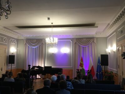 Zdjęcie z koncertu w Pałacu w Jankowicach. Zdjęcie przedstawia salę koncertową i publiczność.
