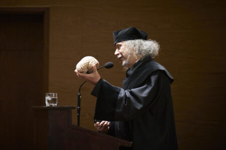 prof. dr hab. Włodzisław Duch z atrapą ludzkiego mózgu w ręce podczas wykładu inauguracyjnego - w todze