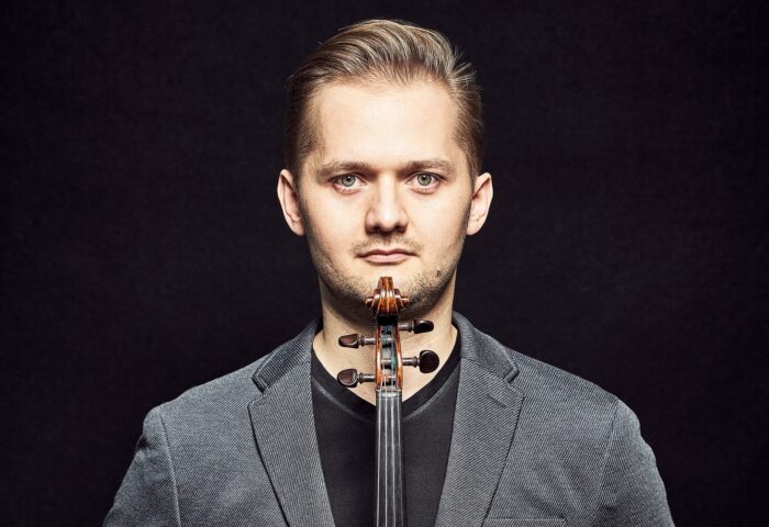 Na zdjęciu widać młodego mężczyznę ze skrzypcami - Jarosława Nadrzyckiego