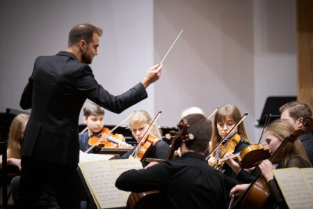 Kolorowe zdjęcie przedstawia dyrygenta i artystów z KOS podczas Koncertu Inauguracyjnego