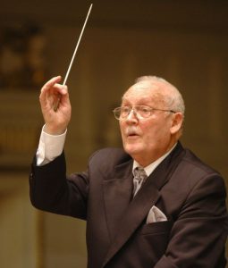 Zdjęcie przedstawia starszego mężczyznę z pałeczką dyrygencką w dłoni -Stefana Stuligrosza
