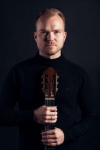 Na zdjęciu mężczyzna z gitarą, Tomasz Kandulski