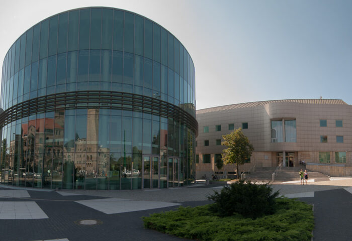 Zdjęcie panoramiczne przedstawia widok wejścia do Akademii Muzycznej i znajdującą się obok Aulę Nova