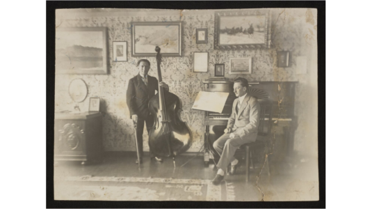 Fotografia przedstawia kontrabasistę, Adama Bronisława Ciechańskigo i Stefana Bolesława Poradowskiego przy fortepianie