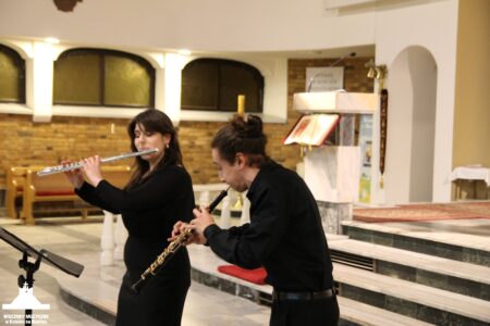 Zdjęcie przedstawia dwie flecistki grające na koncercie w Kościele w Nowinie