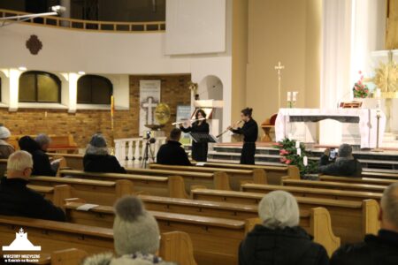 Zdjęcie przedstawia dwie flecistki grające na koncercie w Kościele w Nowinie