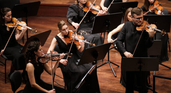 Kolorowe zdjęcie przedstawia kilku czlonków orkiestry podczas koncertu