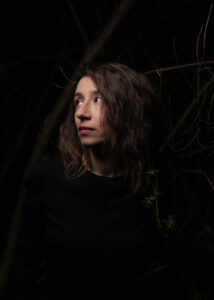 Fidan Aghayeva-Edler - zdjęcie przedstawia artystkę - kobiecą twarz na ciemnym tle