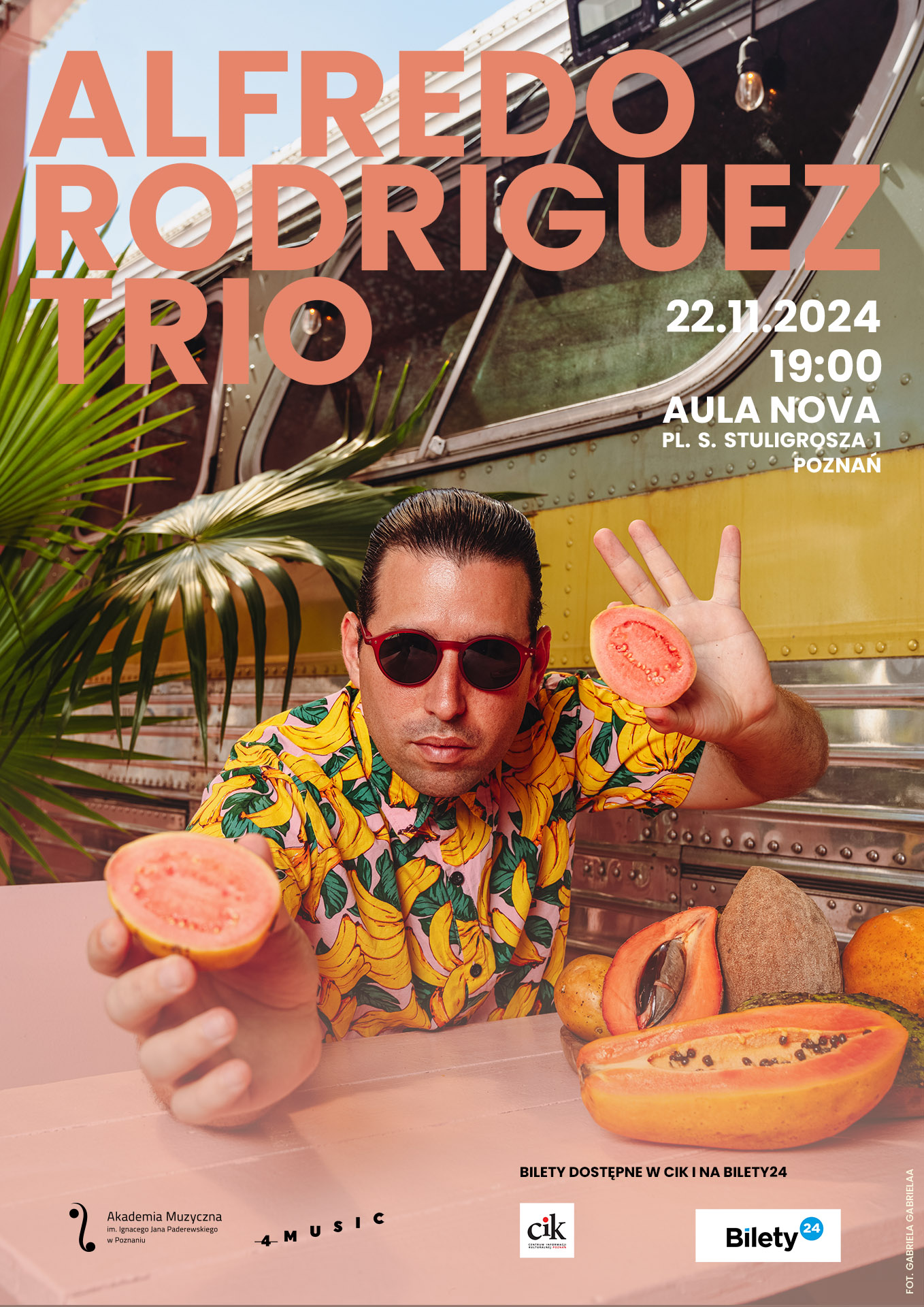 Alfredo Rodriguez_plakat zawiera informacje na temat koncertu w dniu 22 listopada 2024. Na zdjęciu mężczyzna w kolorowej koszuli i okularach przeciwsłonecznych, trzyma w ręku owoc.