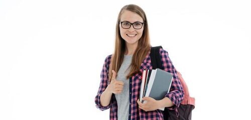 Zdjęcie przedstawia dziewczynę w okularach, z plecakiem na ramieniu i książkami w ręce, typową studentkę.