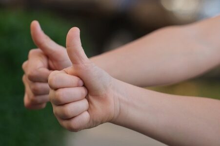 Obrak przedstawia dwie dłonie z usniesionymi kciukami na znak gratulacji
